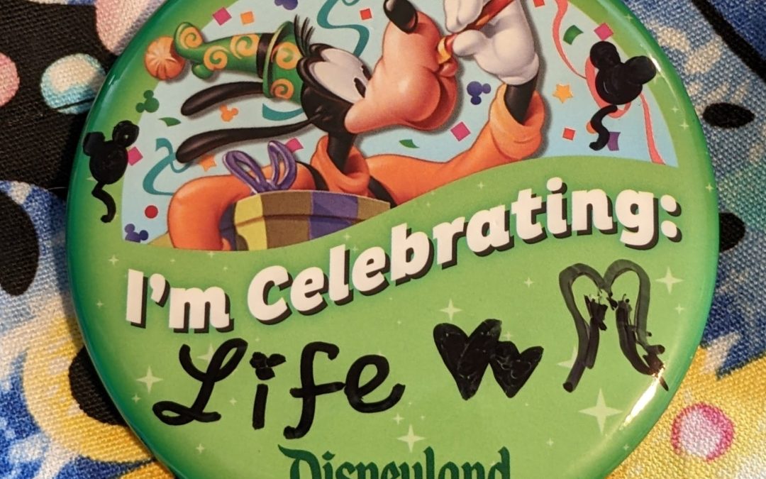 Disneyland pin that says "I'm celebrating Life"