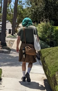 My husband walking away with his hair dyed teal, wearing a utilikilt